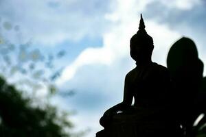 Buddha Statue auf Sonnenuntergang Hintergrund, Buddha Silhouette auf Blau Sonnenuntergang Hintergrund foto