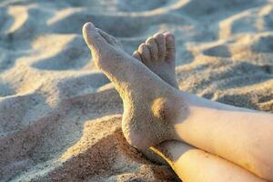 Kinder- Füße im das Sand auf das Strand. Ferien Zeit, Sommer- foto