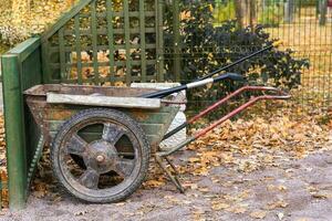 ein Wagen mit Garten Ausrüstung im das Herbst Park foto