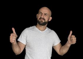 weißer kahlköpfiger Mann mit Bart in einem weißen T-Shirt hält Finger hoch foto