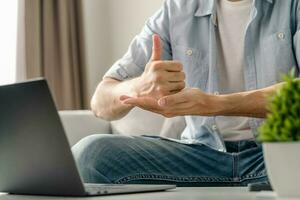 jung taub Mann mit Laptop Computer zum online Video Konferenz Anruf Lernen und kommunizieren im Zeichen Sprache. foto