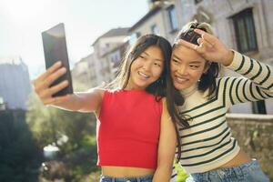 jung asiatisch Frauen tun Selfie zusammen foto