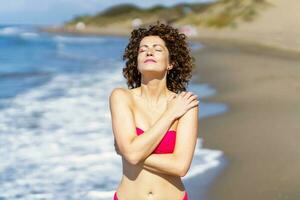 attraktiv Frau im Bikini Stehen auf Strand foto