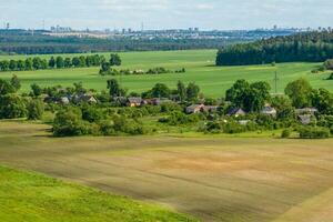 Panorama- Antenne Aussicht von Öko Dorf mit hölzern Häuser, Kies Straße, Gardens und Obstgärten foto