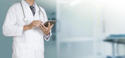 Arzt, der ein digitales Tablett verwendet, das am Krankenhaus arbeitet foto