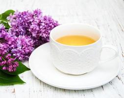 Tasse Tee und lila Blumen