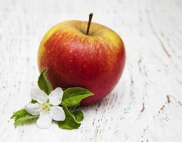 Apfel und Apfelbaumblüten auf einem hölzernen Hintergrund foto