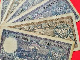 oben Aussicht von alt indonesisch Banknoten RP.10 Rupiah problematisch im 1963. alt Rupiah Währung Konzept isoliert auf ein rot Hintergrund foto