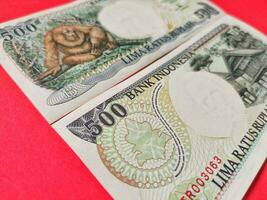 schließen oben Aussicht von alt indonesisch Banknoten Rp. 500,00 problematisch im 1992. Rupiah Währung Konzept isoliert auf ein rot Hintergrund. foto