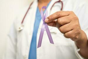 asiatische ärztin mit lila band, zeichen des alzheimer-tages, bauchspeicheldrüsenkrebs, epilepsie, lupus. foto