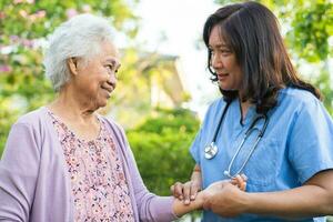 Arzt Pflegekraft Hilfe und Pflege asiatisch Senior Frau geduldig gehen mit Gehhilfe im Park beim Krankenhaus. foto