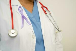 asiatische ärztin mit lila band, zeichen des alzheimer-tages, bauchspeicheldrüsenkrebs, epilepsie, lupus. foto