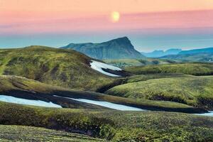 Landschaft von vulkanisch Berg Hügel mit Moos bedeckt und das Mond im Sonnenuntergang Himmel auf isländisch Hochland im Sommer- beim Island foto