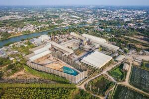 Zucker Stock Biomasse wird bearbeitet Pflanze mit Lagerhaus, Panzer und Mähdrescher LKW im Fabrik foto