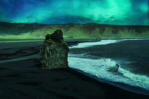 Landschaft von Aurora Borealis glühend Über Kirkjufjara schwarz Sand Strand mit Adler Felsen im das Nacht beim Island foto