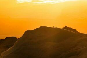 Vogel thront auf Eisberg mit Orange Sonnenuntergang Himmel foto