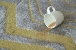 Tasse von Kaffee verschüttet auf grau Farbe Teppich foto