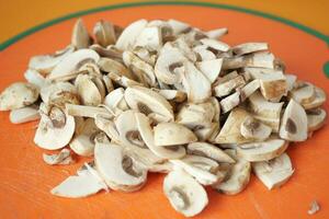 Scheibe von Champignons Pilz auf Hacken Tafel foto