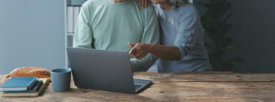 umarmt reifen Paar Surfen das Internet auf Laptop beim Zuhause foto