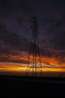 hoch Stromspannung Leistung Linie Turm mit schön Himmel beim Sonnenuntergang, Lager Foto