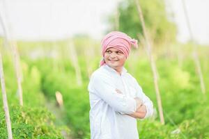 jung indisch Farmer zeigen Clever Telefon , Farmer reden auf Telefon im Bauernhof, glücklich indisch Farmer foto