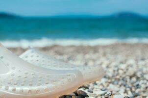 aqua Schuhe auf Strand Sommer- Tag selektiv Fokus foto