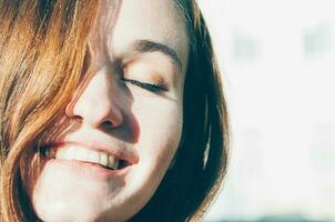 Nahansicht sommersprossig Brünette jung Frau lächelnd Augen geschlossen foto