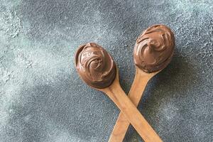 zwei hölzern Löffel von Schokolade Sahne foto