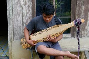 kuaro Kalimantan Timur, Indonesien 21 Juni 2023. ein Mann spielen ein traditionell Kalimantan Dayak Musical Instrument foto