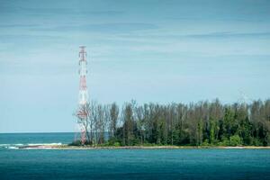 Insel im das Mitte von das Meer und Elektrizität Stangen beim Thailand. foto