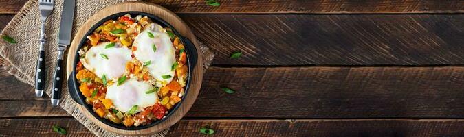 Shakshouka im braten Pfanne. gebraten Eier mit Gemüse, Tomate, Pfeffer, Kürbis und Zwiebel. oben Aussicht foto