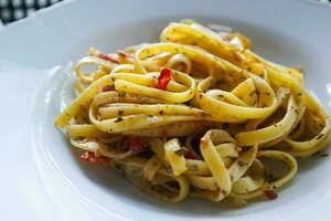 Aglio e Olio. Italienisch Pasta Spaghetti, Aglio olio e Peperoni ,Spaghetti mit Knoblauch, Olive Öl und Chili Pfeffer auf Teller auf Tabelle foto