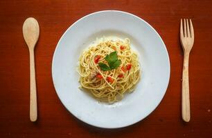 Aglio e Olio. Italienisch Pasta Spaghetti, Aglio olio e Peperoni ,Spaghetti mit Knoblauch, Olive Öl und Chili Pfeffer auf Teller auf Tabelle foto