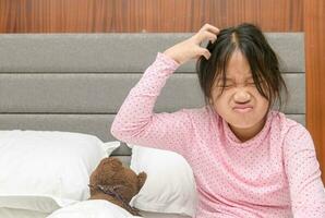 Mädchen juckend ihr Haar oder frustriert auf Bett, Problem Gesundheit Haar foto