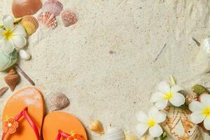 oraneg Sandale mit Muscheln und Plumeria Blumen auf Sand foto