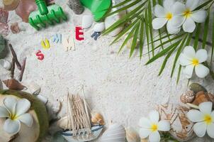 Sommer- Text mit Muscheln und Plumeria Blumen auf Sand foto