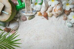 Muscheln und Plumeria Blumen auf Sand Hintergrund, foto