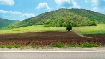 horizontal Aussicht von Asphalt Straße im Thailand. Hintergrund von bereiten Boden zum Plantage. Hügel und Mountin unter Blau Himmel und Weiß Wolken. foto