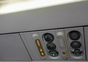 Belüftung Zeichen und Kontrollen auf das Decke im ein Flugzeug während Flug foto