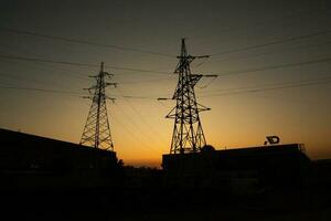 Hochspannung Leistung Linien beim Sonnenuntergang. Elektrizität Verteilung Bahnhof. Elektrizität Pylone auf das Hintergrund von das Himmel foto