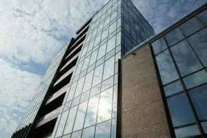 modern Büro Gebäude mit Glas Fassade und Blau Himmel. Geschäft Hintergrund. modern die Architektur im das Stadt foto