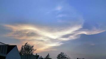 Sonnenuntergang im das Abend mit dramatisch gestalten und Farbe von Wolken und Himmel mit Silhouette von Gehäuse und Bäume, Horizont, Wolkengebilde, Natur Hintergrund foto