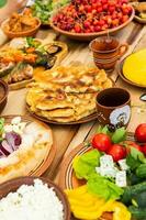 hausgemacht rumänisch Essen mit gegrillt Fleisch, Polenta und Gemüse Teller auf Camping. romantisch traditionell Moldawier Essen draußen auf das Holz Tisch. foto