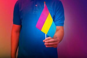 Hand halten Flagge im schwenken Sexual- Stolz Farben. foto