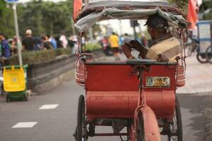 magelang,indonesien.juni 4, 2023-a Rikscha Treiber wartet zum Menschen Wer wollen zu gehen um Stadt, Dorf durch Rikscha. foto