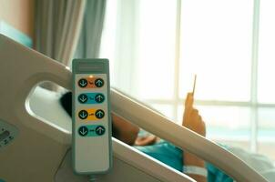 Krankenhaus Bett Fernbedienung Steuerung hängend auf das Bett Schiene mit Frau geduldig auf Bett im Krankenhaus Zimmer. foto