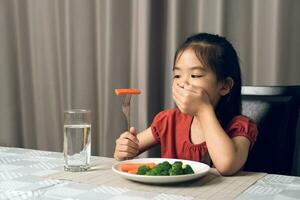 wenig süß Kind Mädchen ablehnen zu Essen gesund Gemüse. Kinder tun nicht mögen zu Essen Gemüse. foto