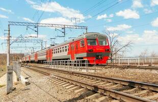 ein elektrisch Zug läuft auf rostig Eisenbahn Spuren gegen ein Blau Himmel mit Weiß Wolken. foto