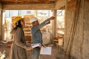 Porträt von Ingenieur und Architekt Arbeiten zusammen auf Konstruktion Grundstück, beide tragen Sicherheit Helme. foto