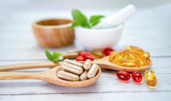 Alternative Medizin Kräuter-Bio-Kapsel mit Vitamin E Omega-3-Fischöl Mineralstoff mit Kräuterblatt natürliche Ergänzungen für ein gesundes Leben foto